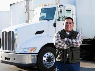 man smiling in front a truck