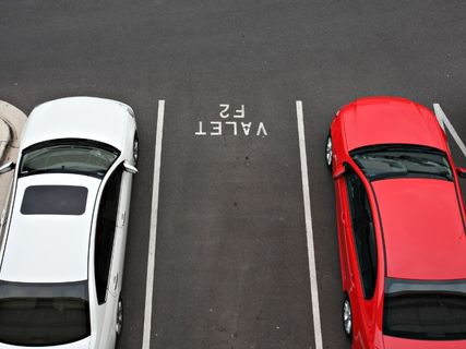 two cars in a parking lot with a free space between