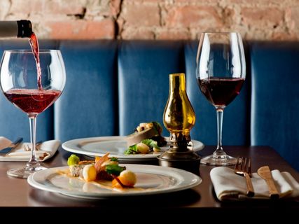 two cups with wine with food on a table